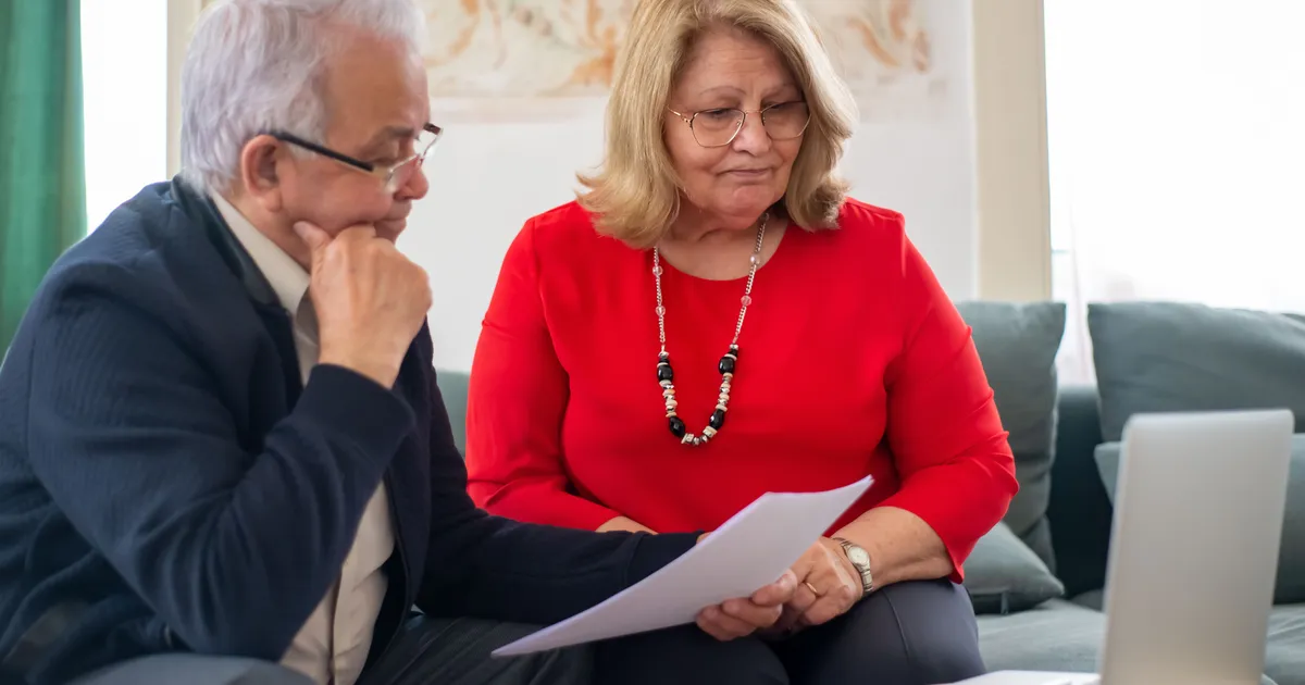 Ouder echtpaar bekijkt samen financiële documenten